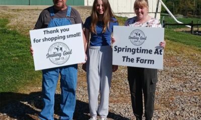the smiling goat soap company family holding up white custom signs