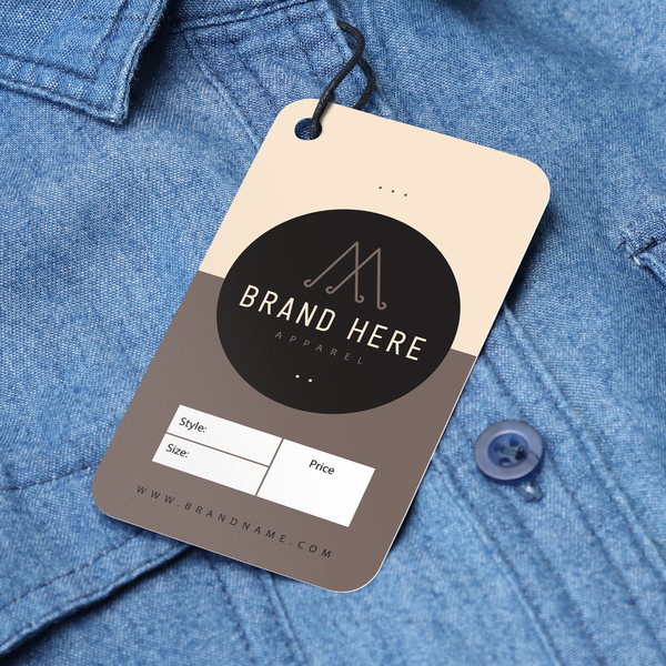 Die-cut hang tag attached to a denim shirt with minimalist branding.