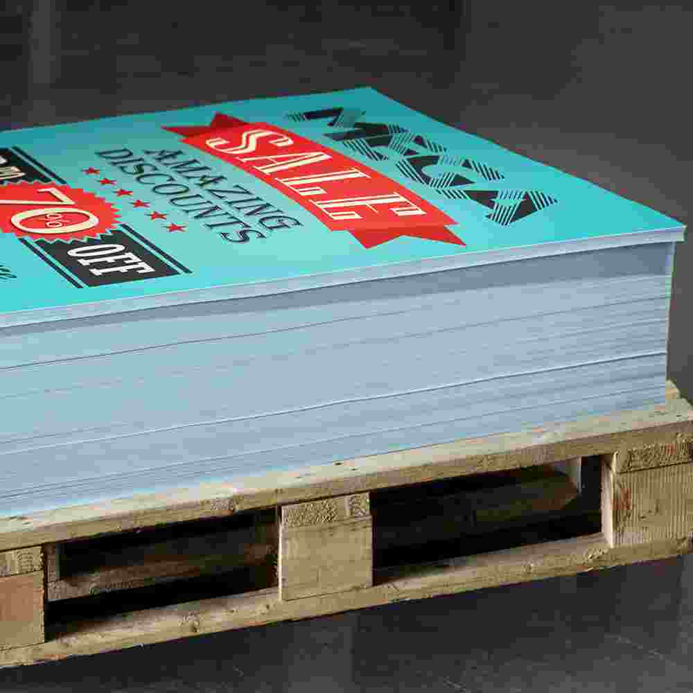 Stack of bulk printed promotional flyers on a wooden pallet