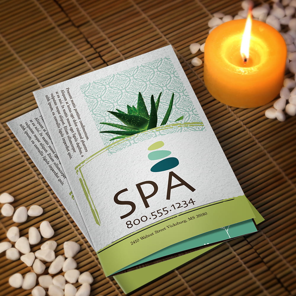 A spa brochure displayed on a bamboo mat beside a lit candle