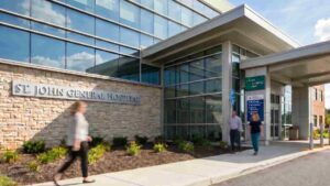 People walking outside hospital entrance.
