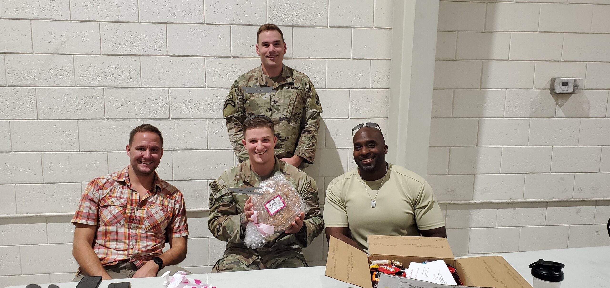 US Marines smiling holding a pastry