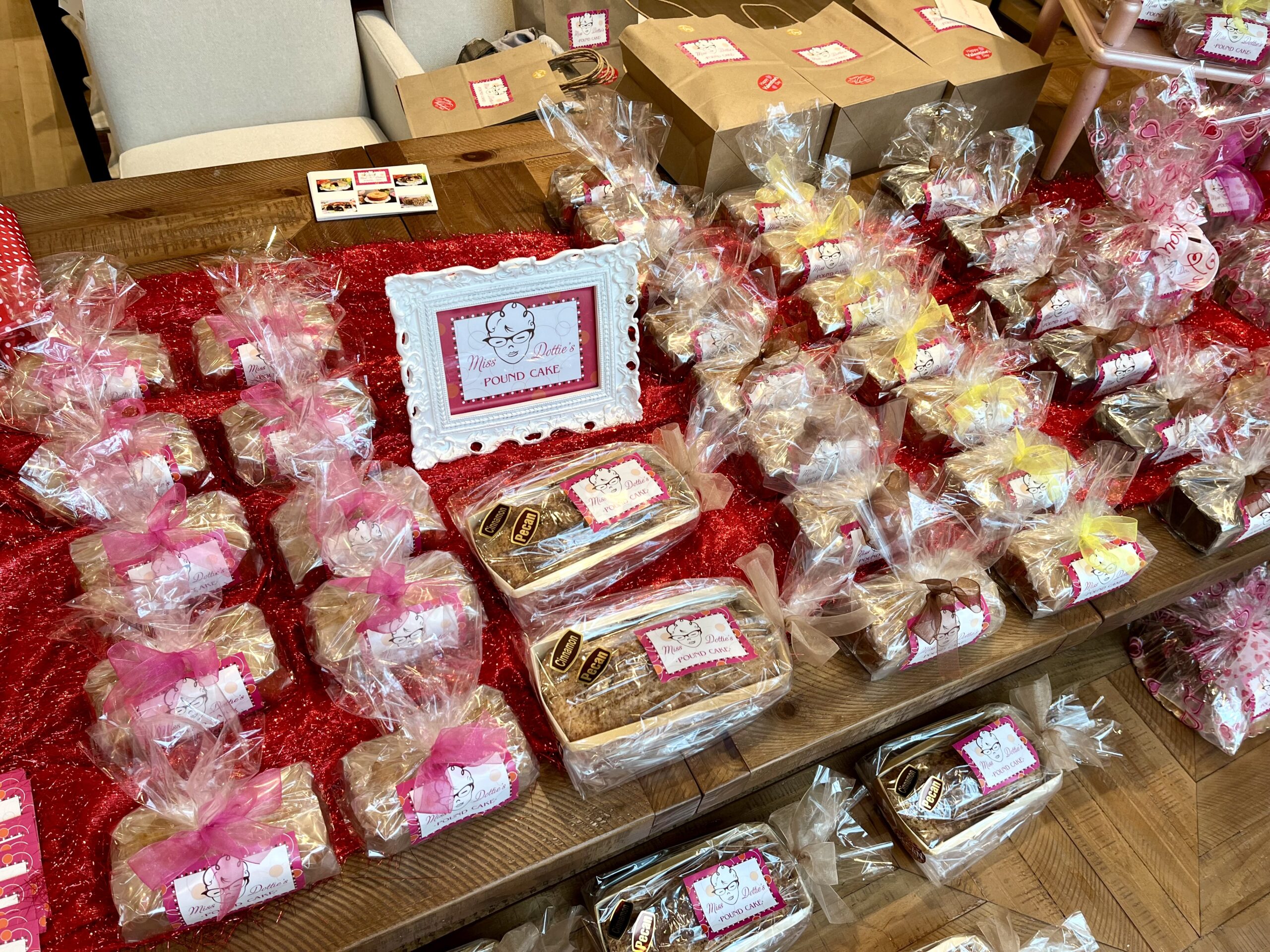table spread of pound cakes wrapped in clear and pink packaging with hang tags and labels
